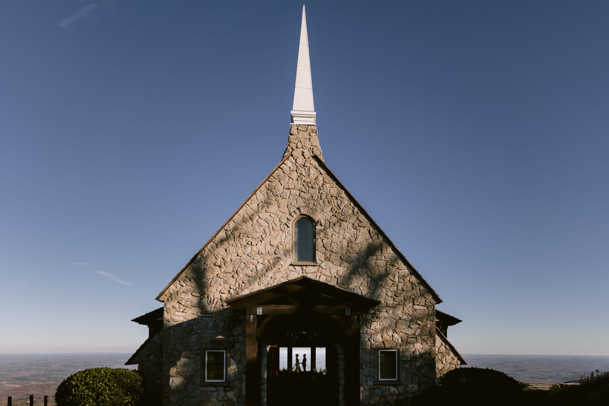 Silhouette of bride and groom through open doors of Cliffs at Glassy Chapel