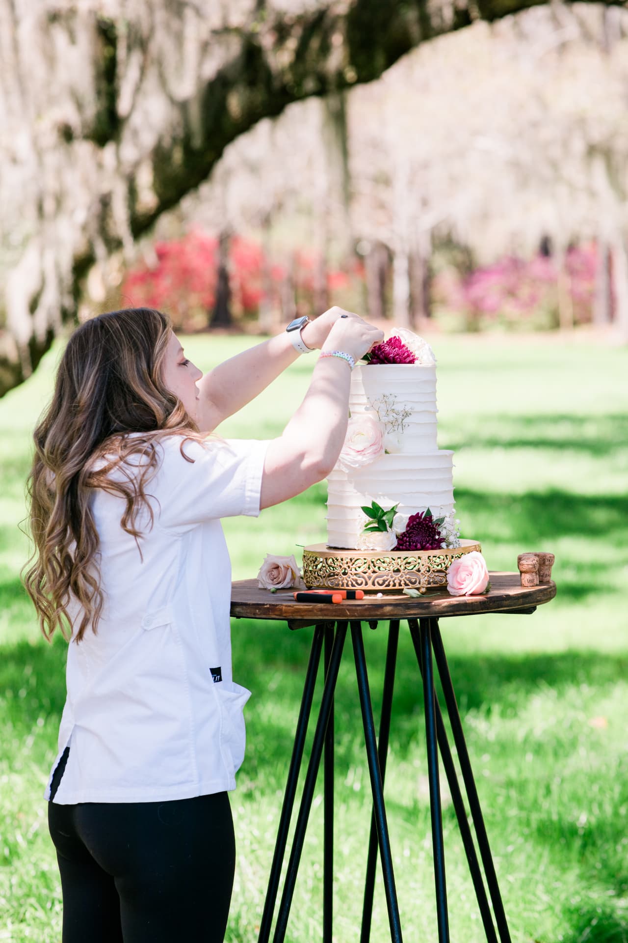 Spilled Milk Cake Boutique - Alexandra Kowaleski finishing a custom cake outdoors